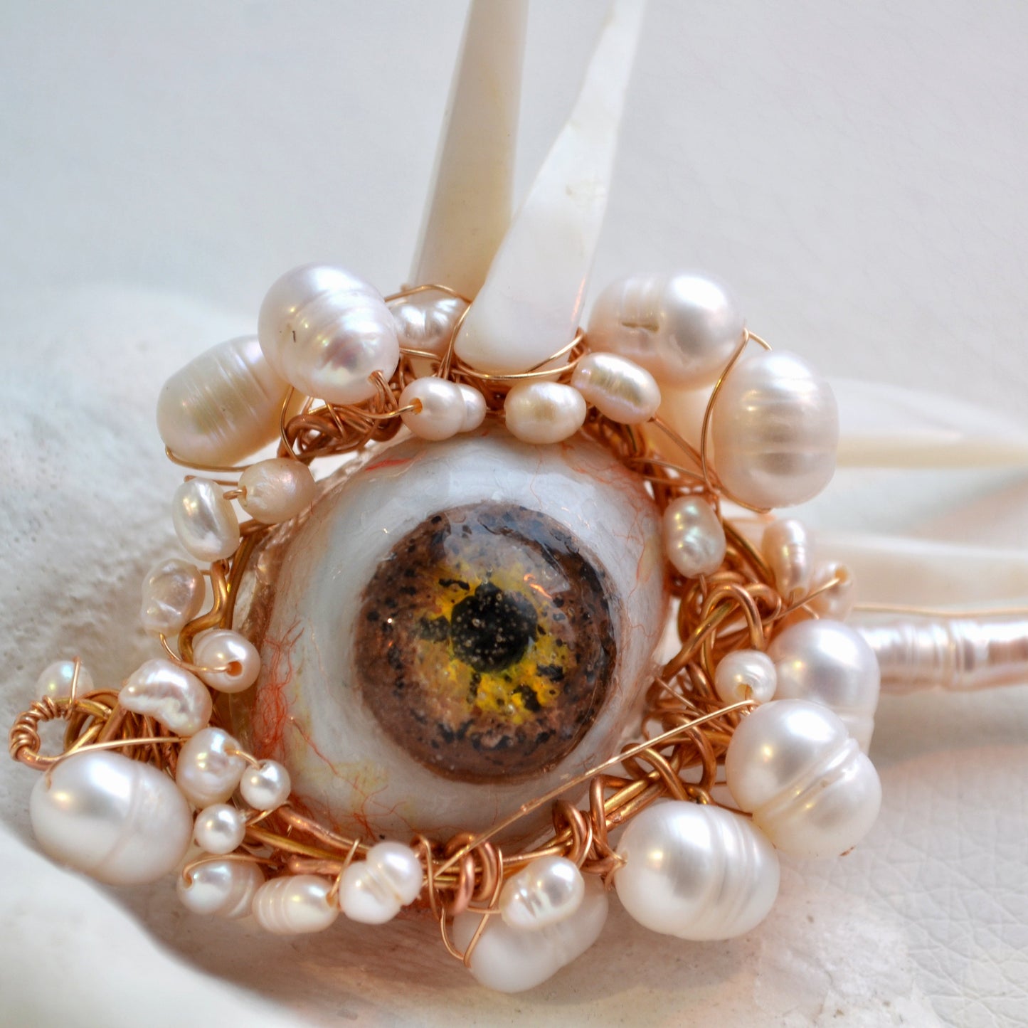 brooch with pearls and a central stone on a white background