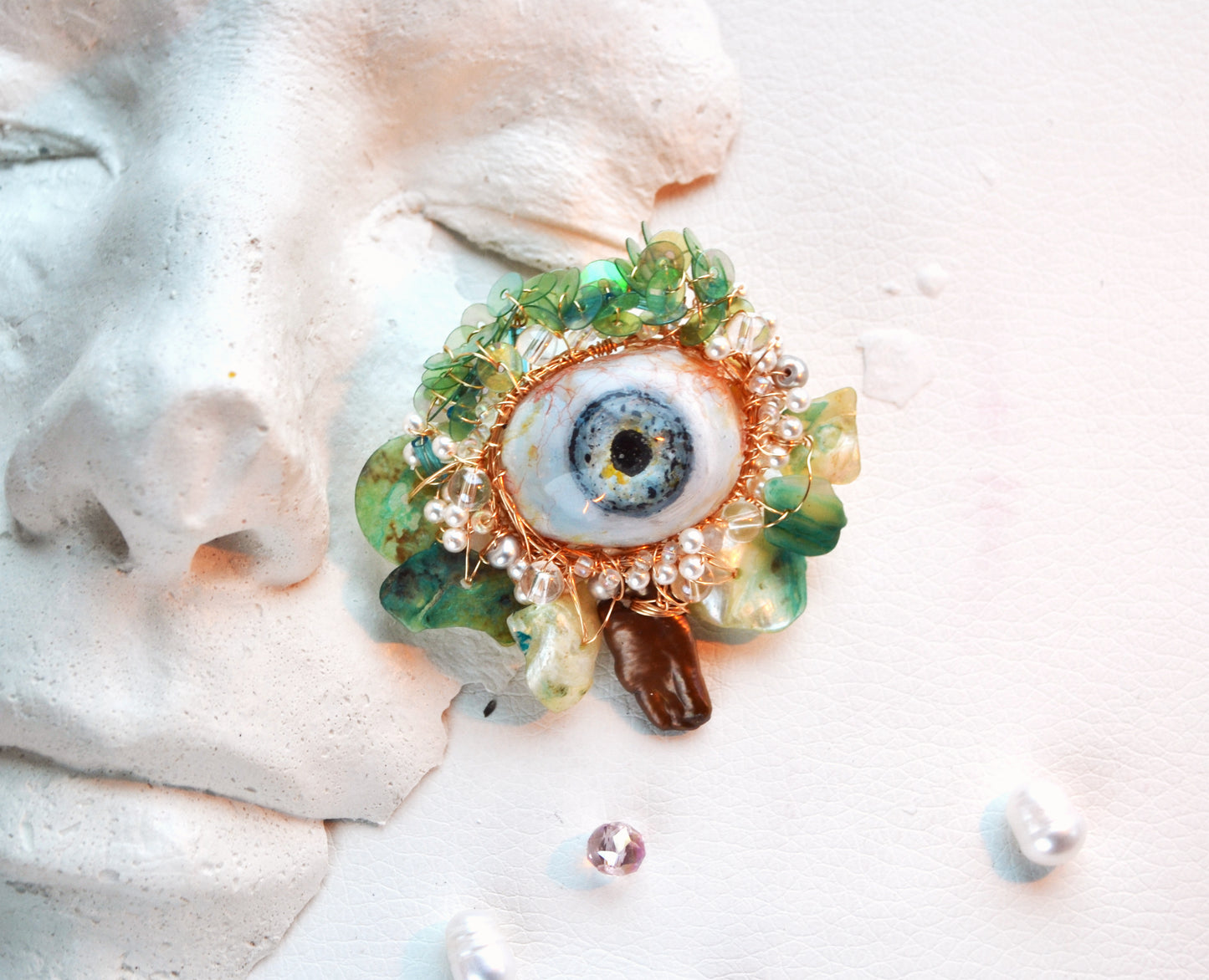 Decorative brooch with eye design on a white surface