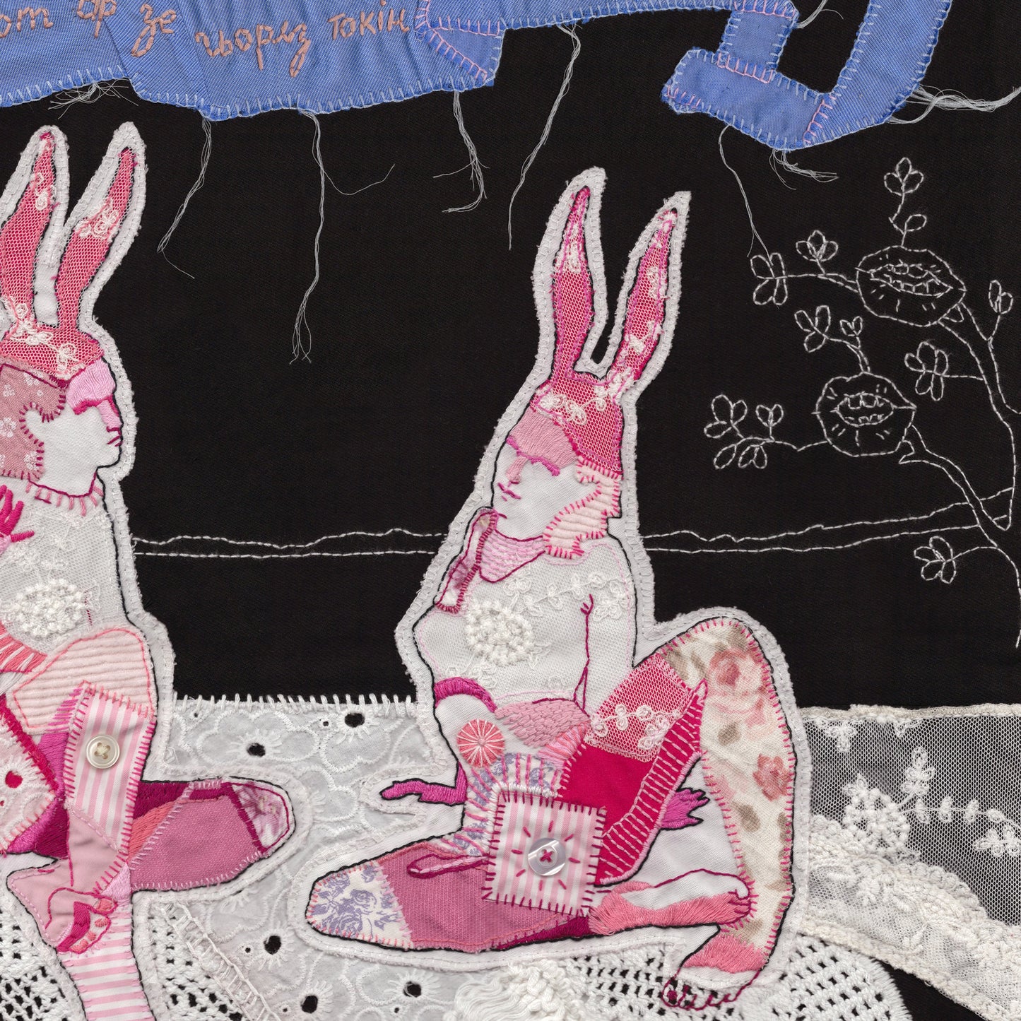 Embroidered patch of a rabbit character on a black background with floral details.