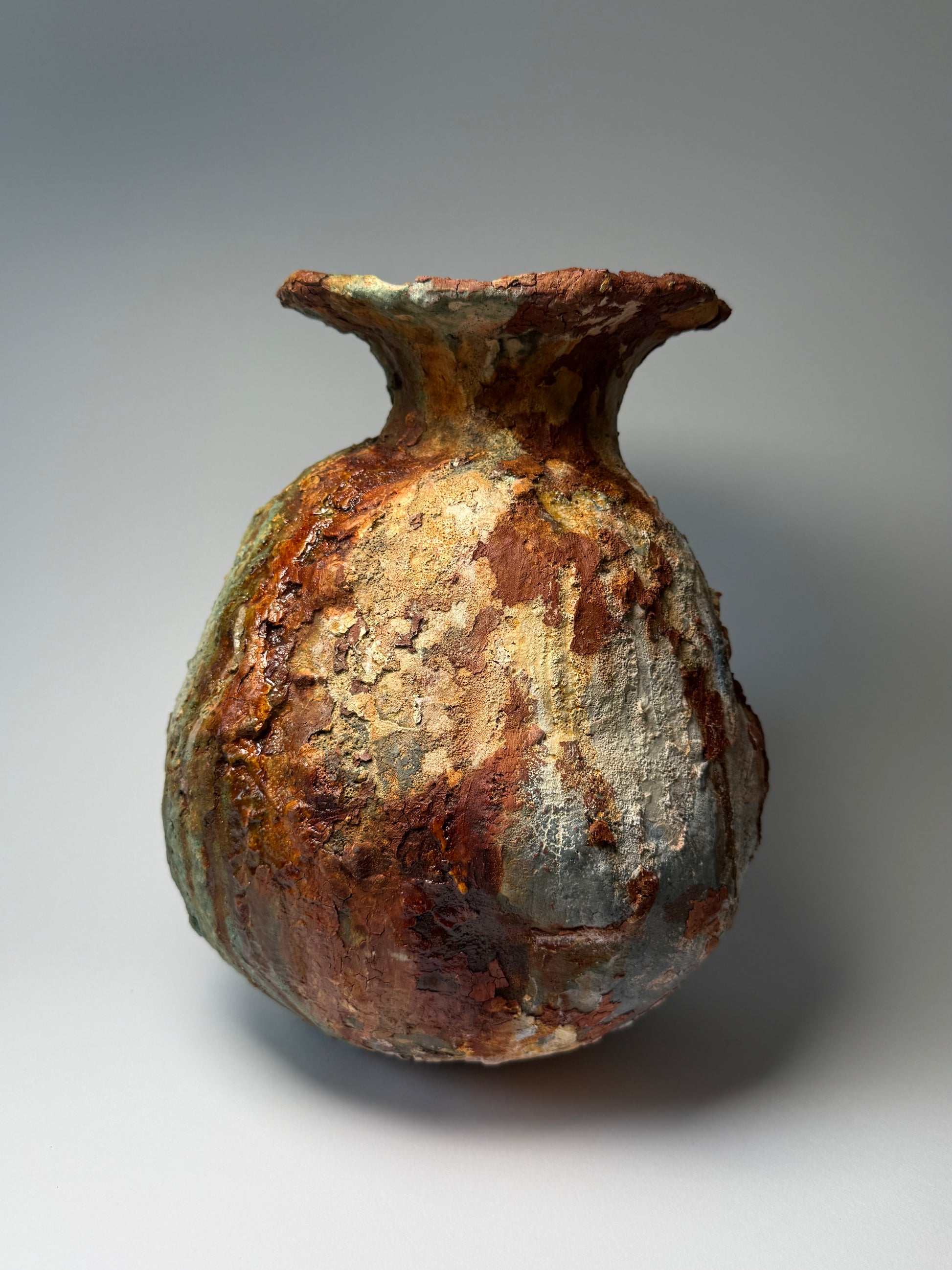 Rust-colored ceramic vase on a gray background