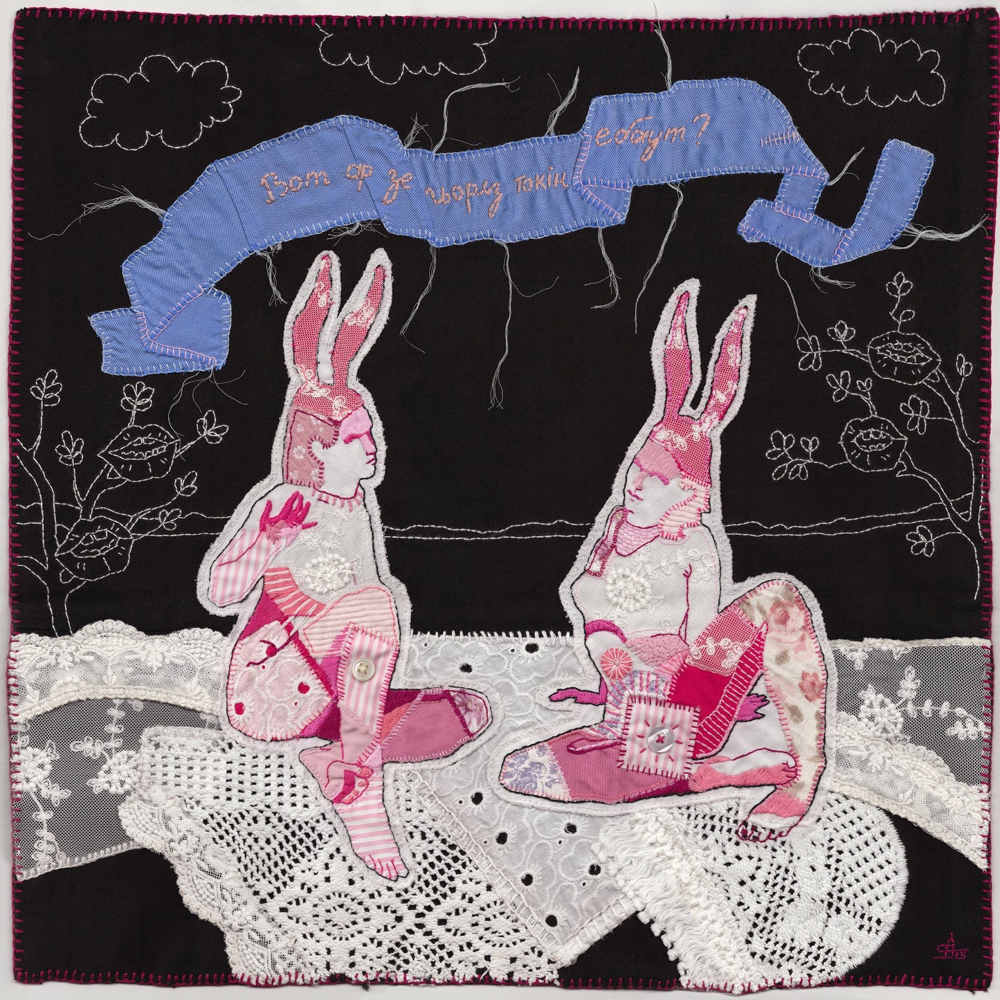 Quilt with embroidered bunnies and text on a black background