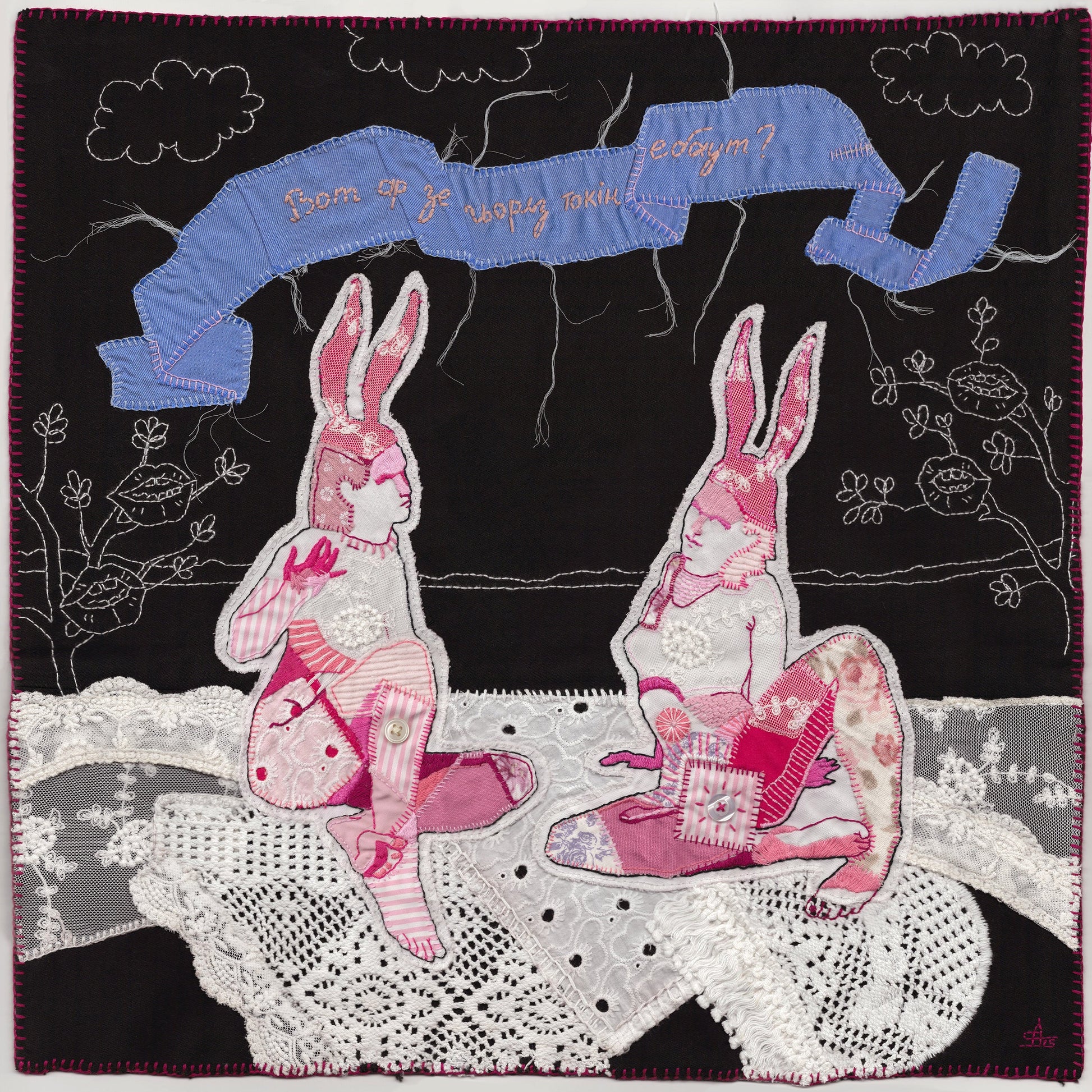 Quilt with embroidered bunnies and text on a black background