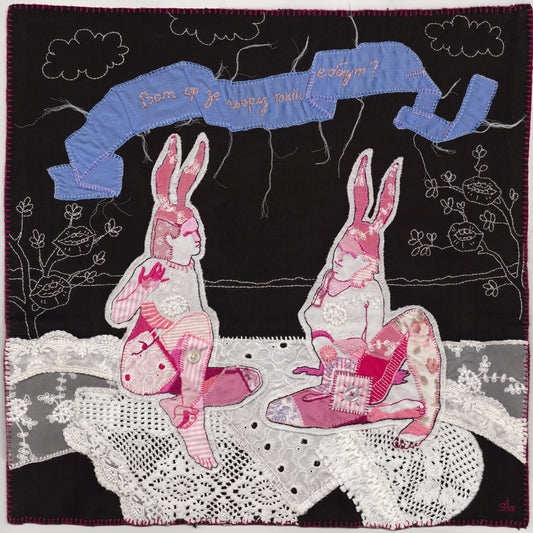 Quilt with embroidered bunnies and text on a black background