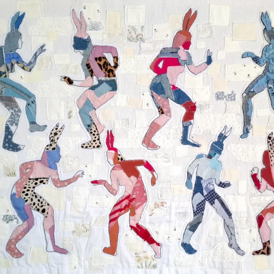Quilt with colorful patterns of stylized figures on a white background