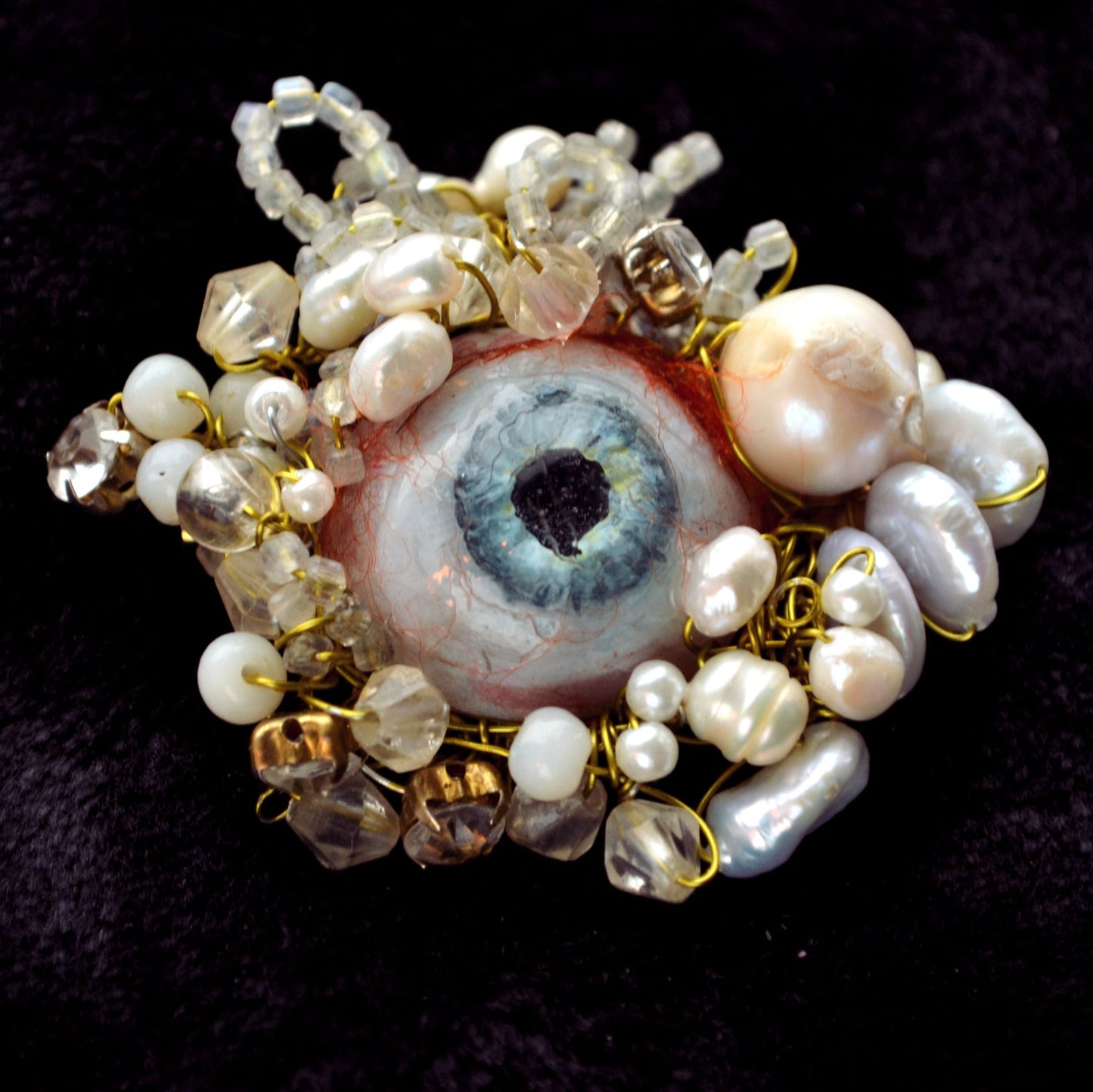 Artificial eye surrounded by pearls and beads brooch by Polina Verbytska, Witness III