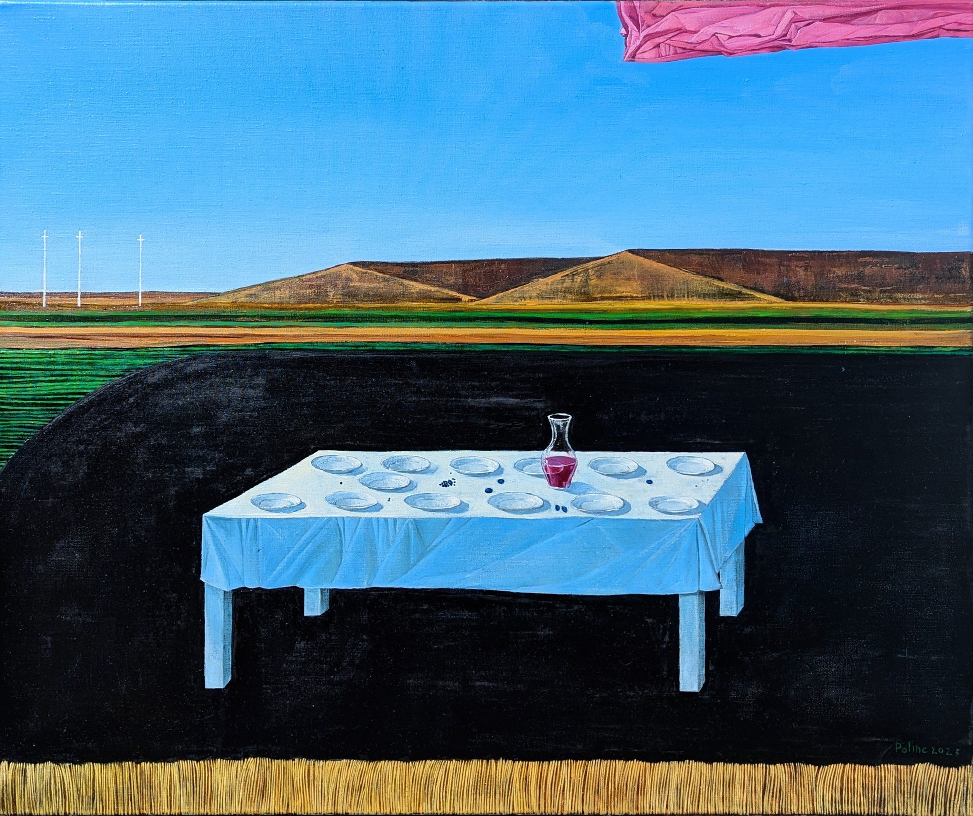 Table with blue tablecloth and white plates set against a landscape with hills and blue sky.