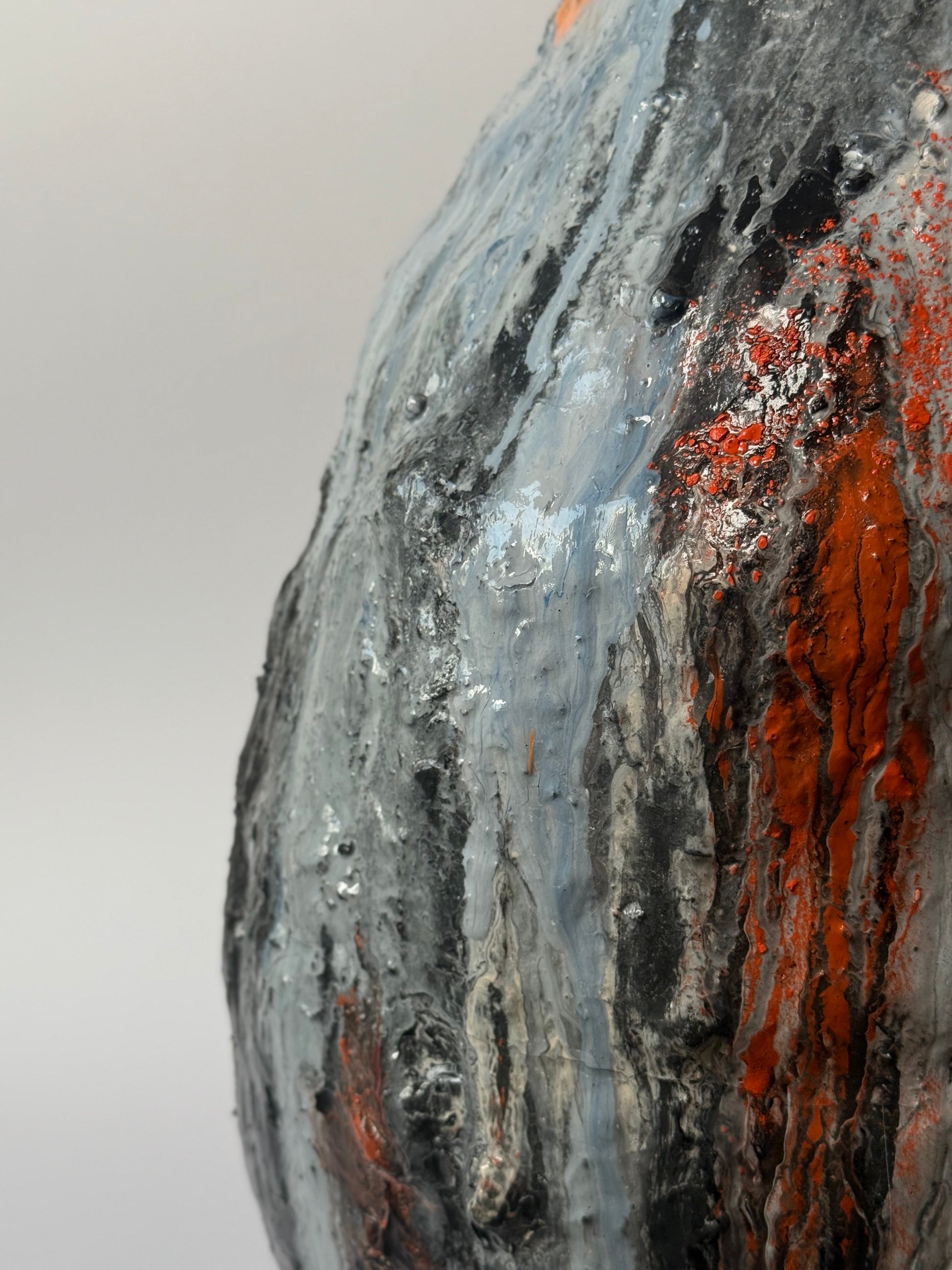 Close-up of a textured surface with orange and gray colors on a light gray background