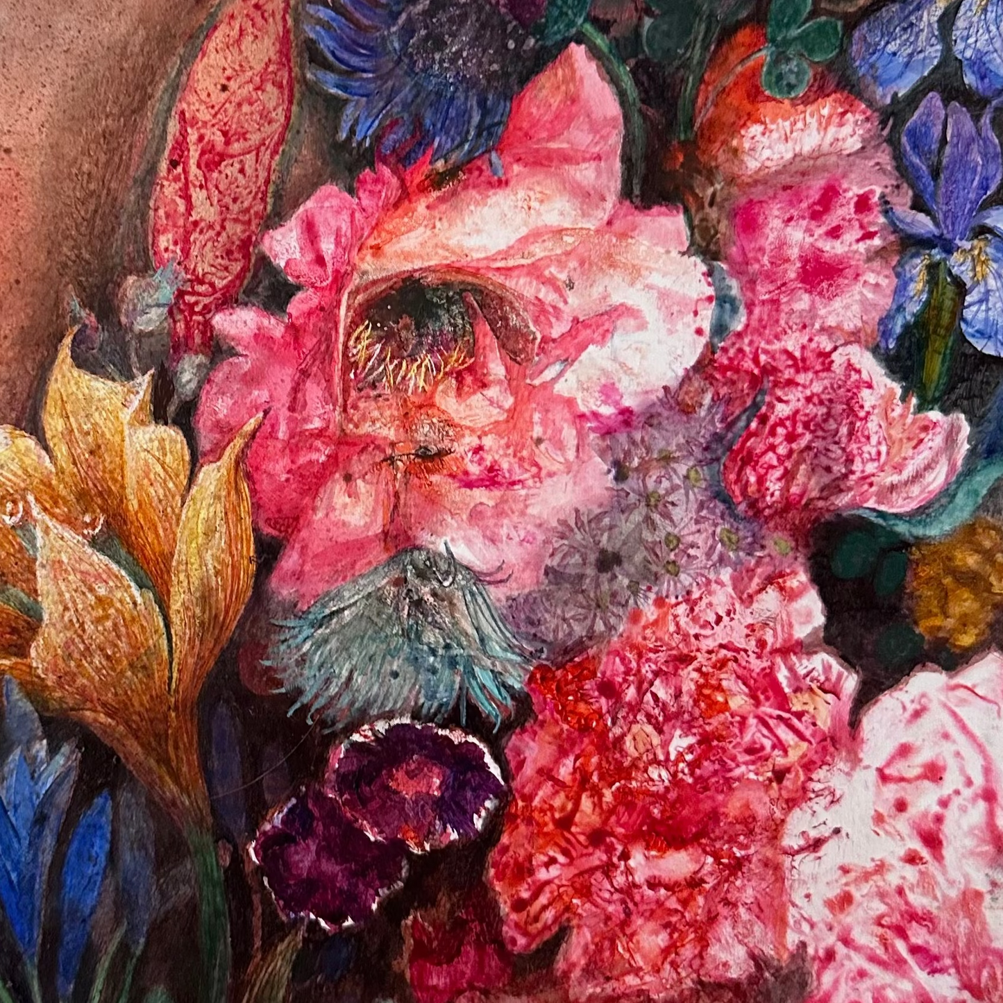 Close-up of a vibrant floral arrangement with pink, red, and blue flowers on a textured background.