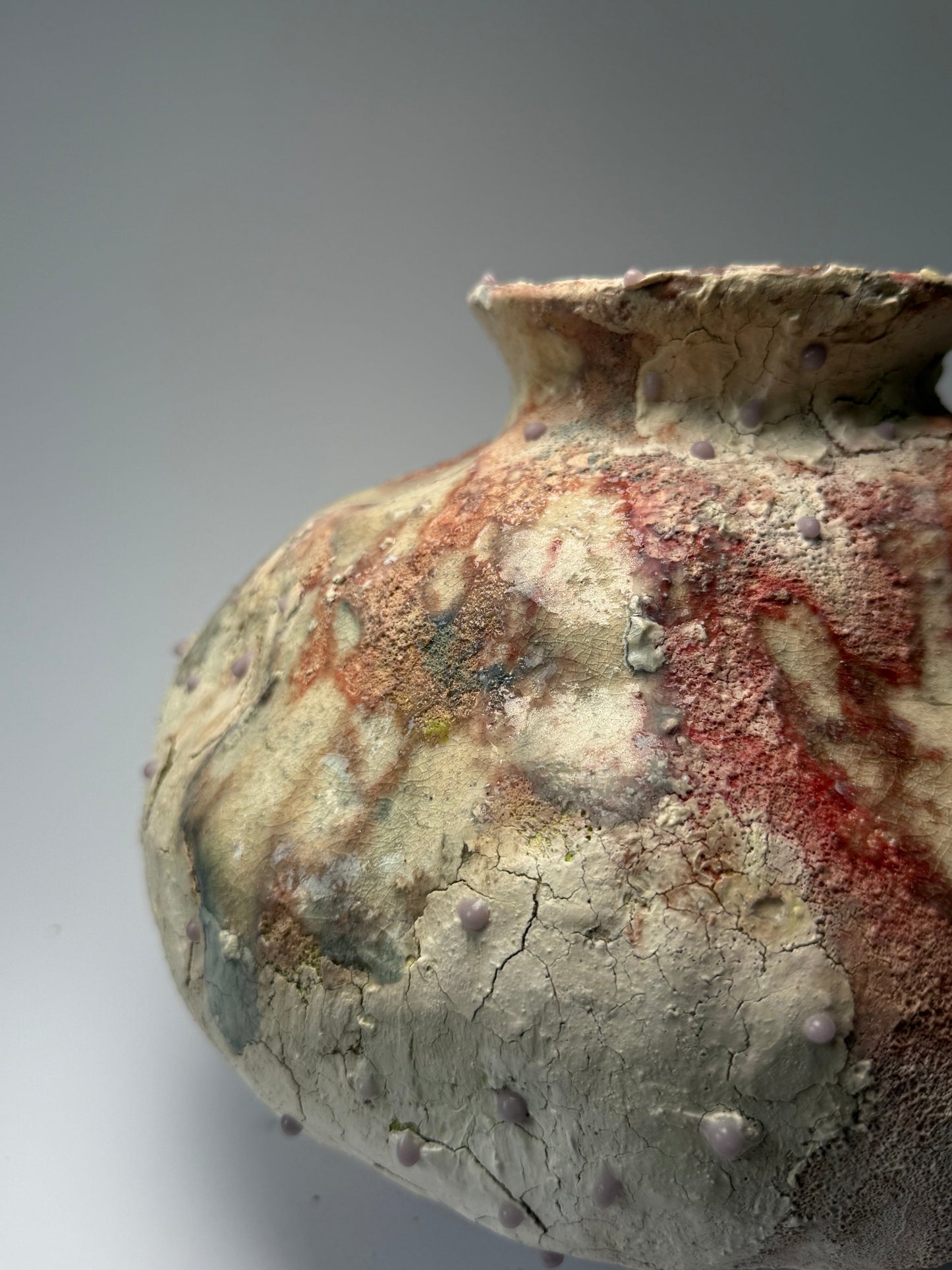 Close-up of decorative ceramic vase with textured surface on a gray background