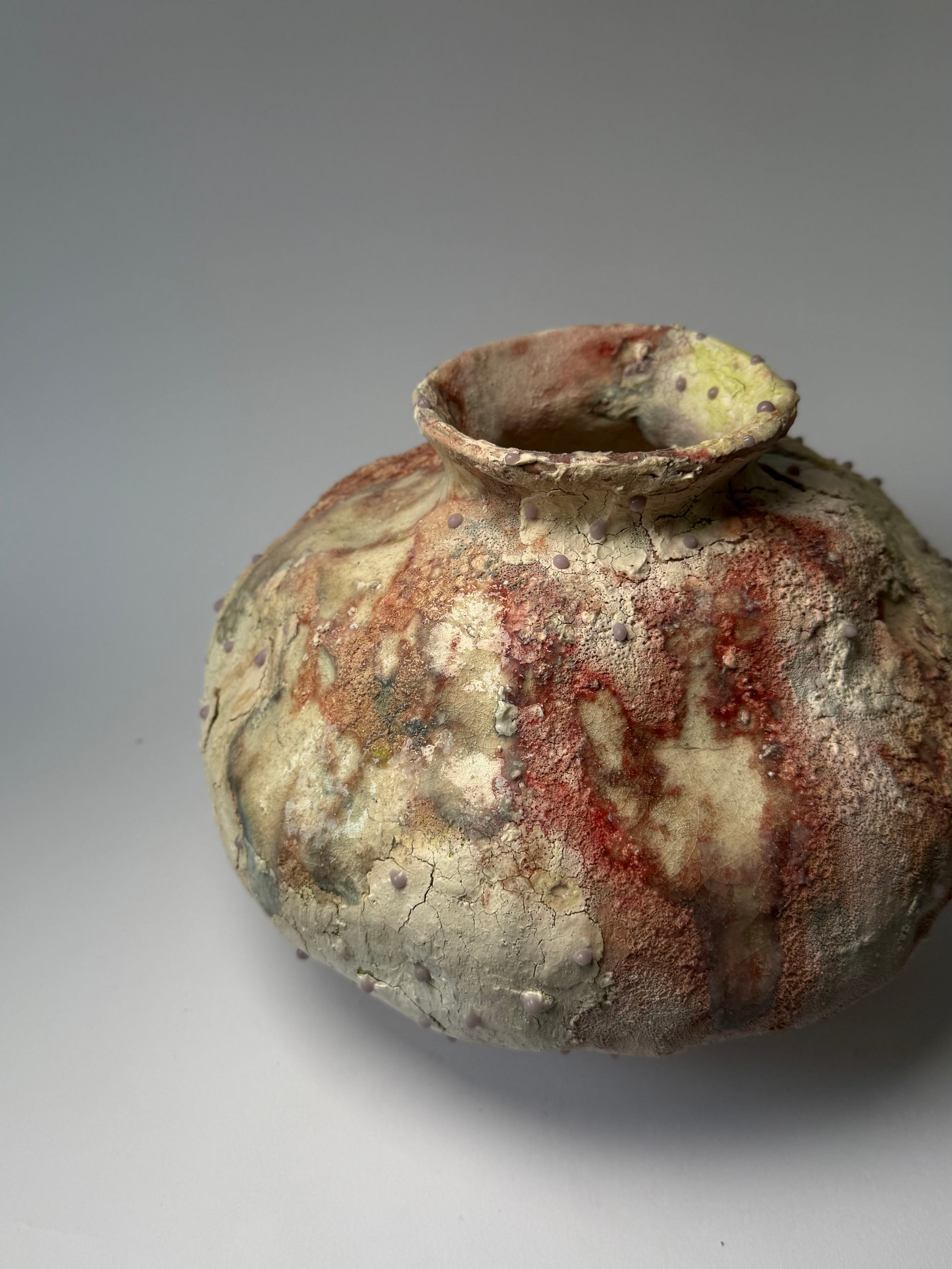 Close-up of decorative ceramic vase with textured surface on a gray background