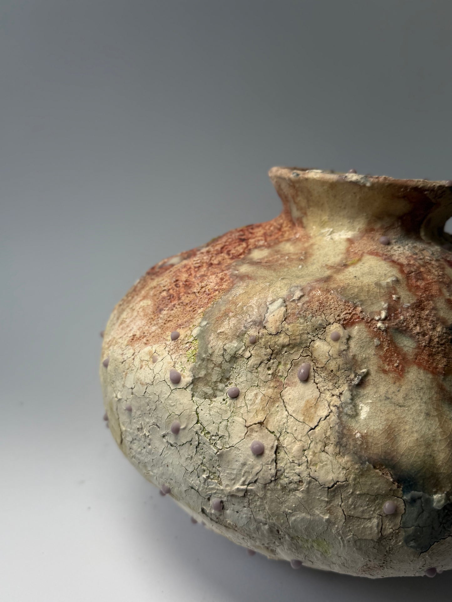 Close-up of decorative ceramic vase with textured surface on a gray background