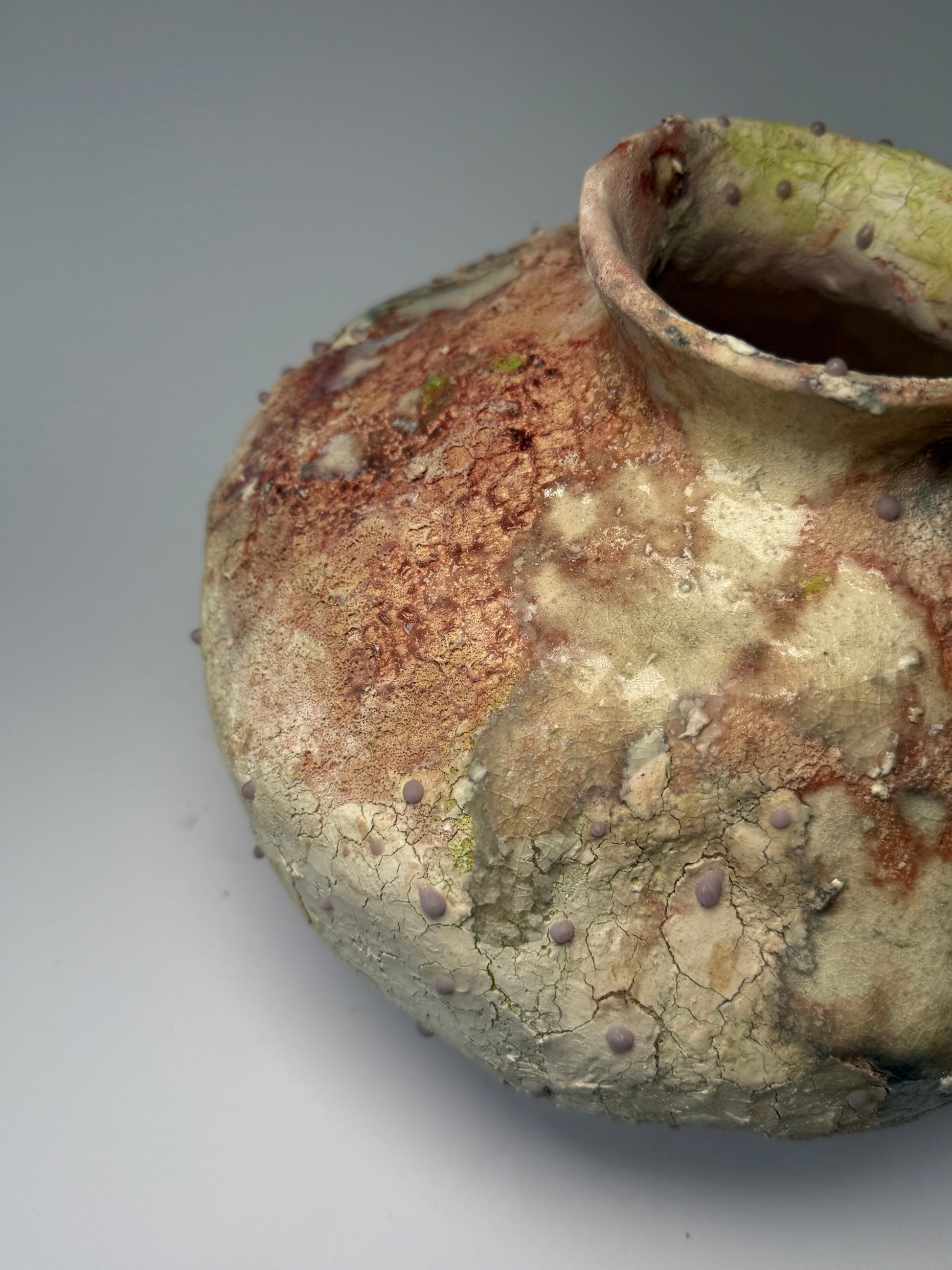 Close-up of decorative ceramic vase with textured surface on a gray background