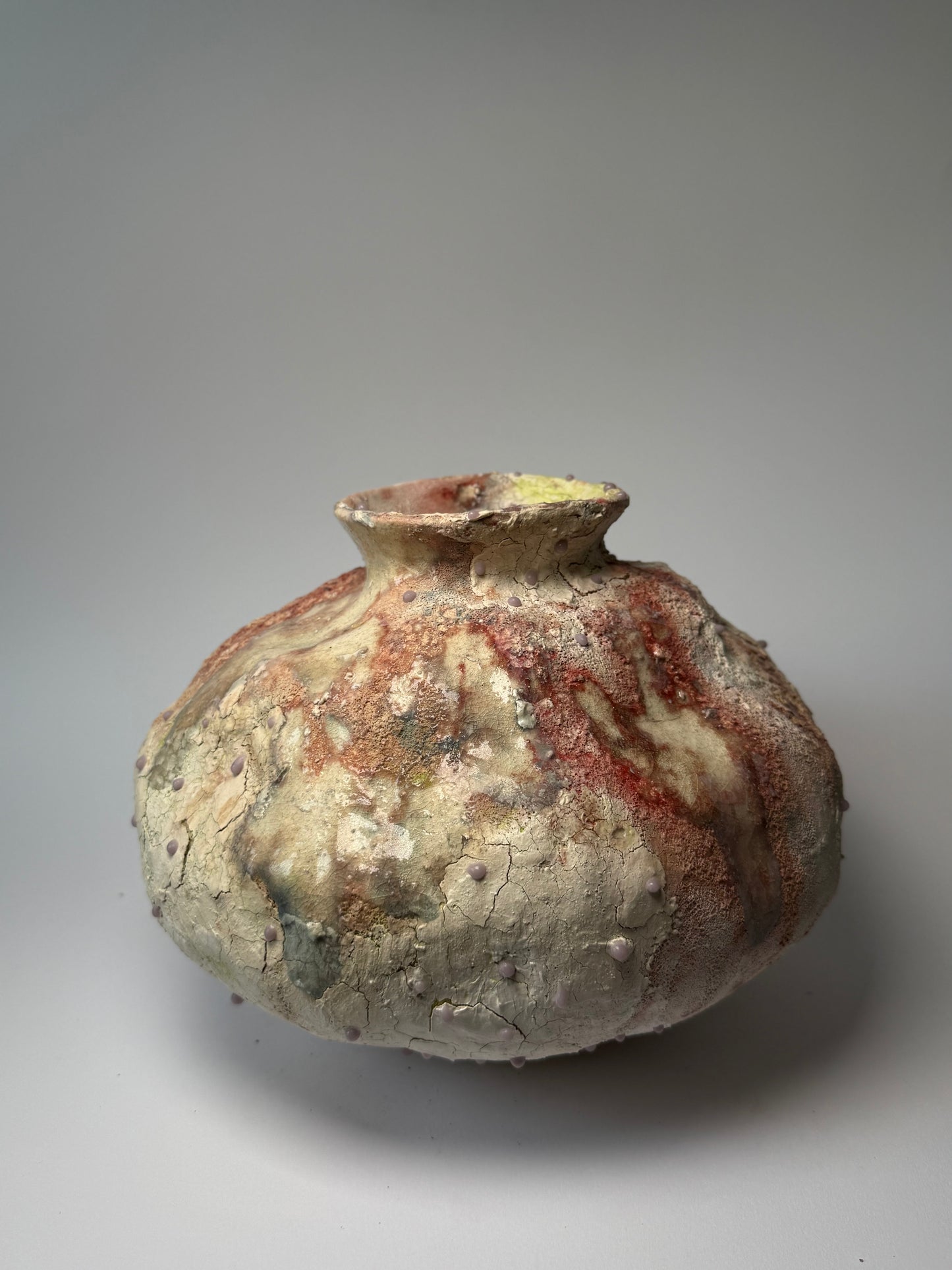 Decorative ceramic vase with textured surface on a gray background