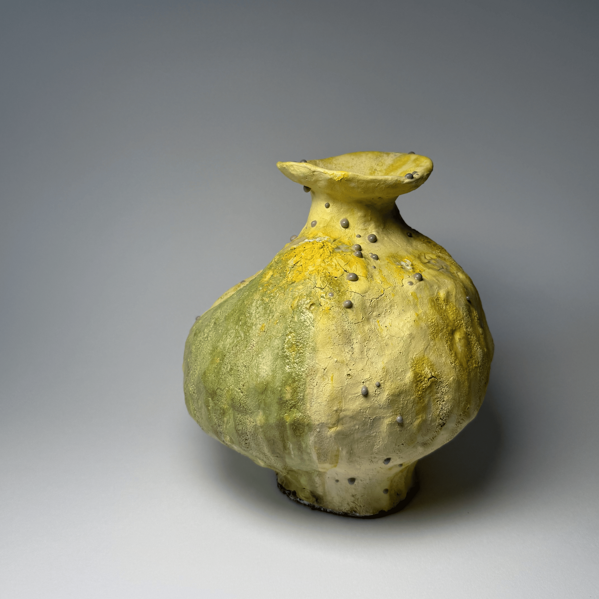 Ceramic vase with a textured surface on a gray background