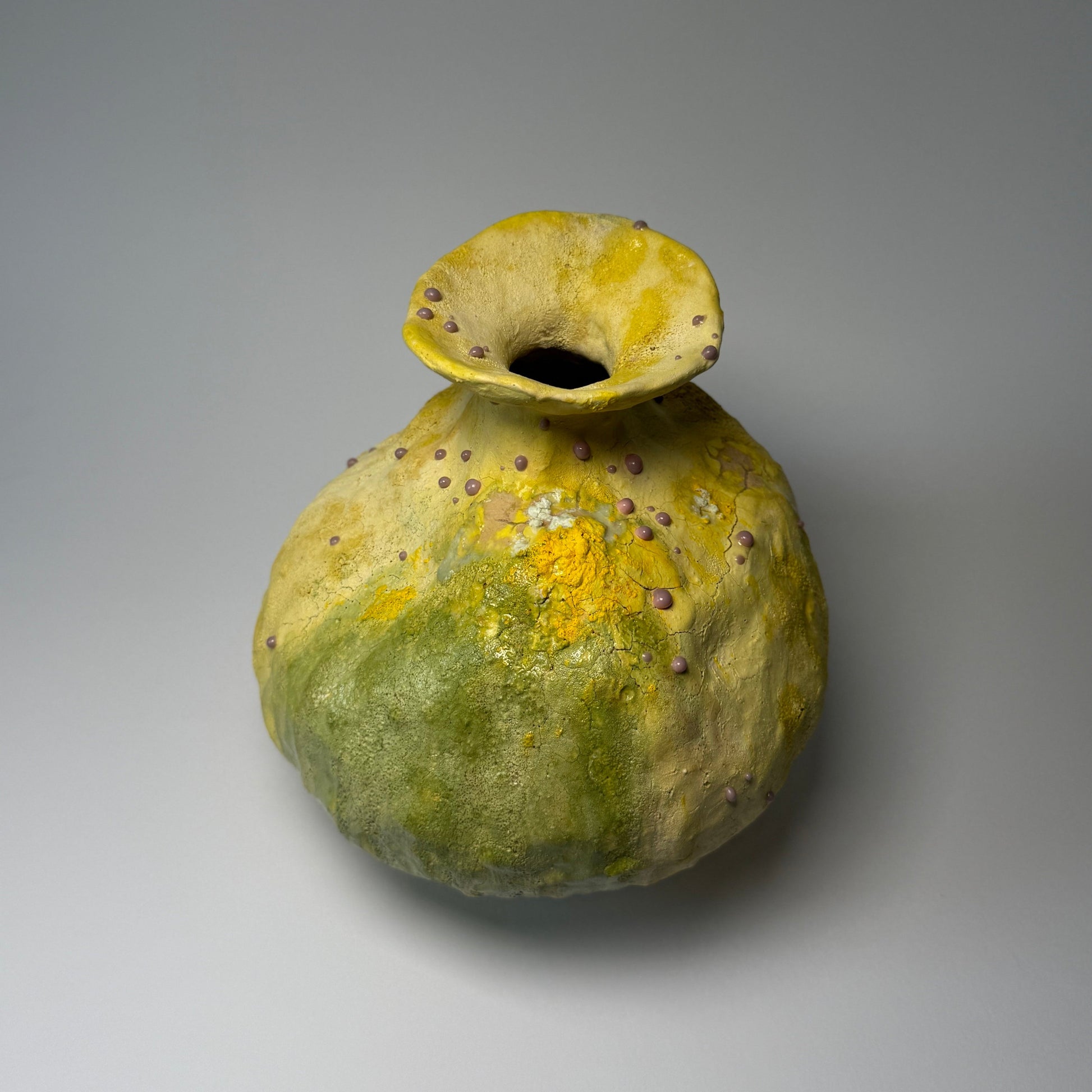 Yellow and green ceramic vase on a gray background