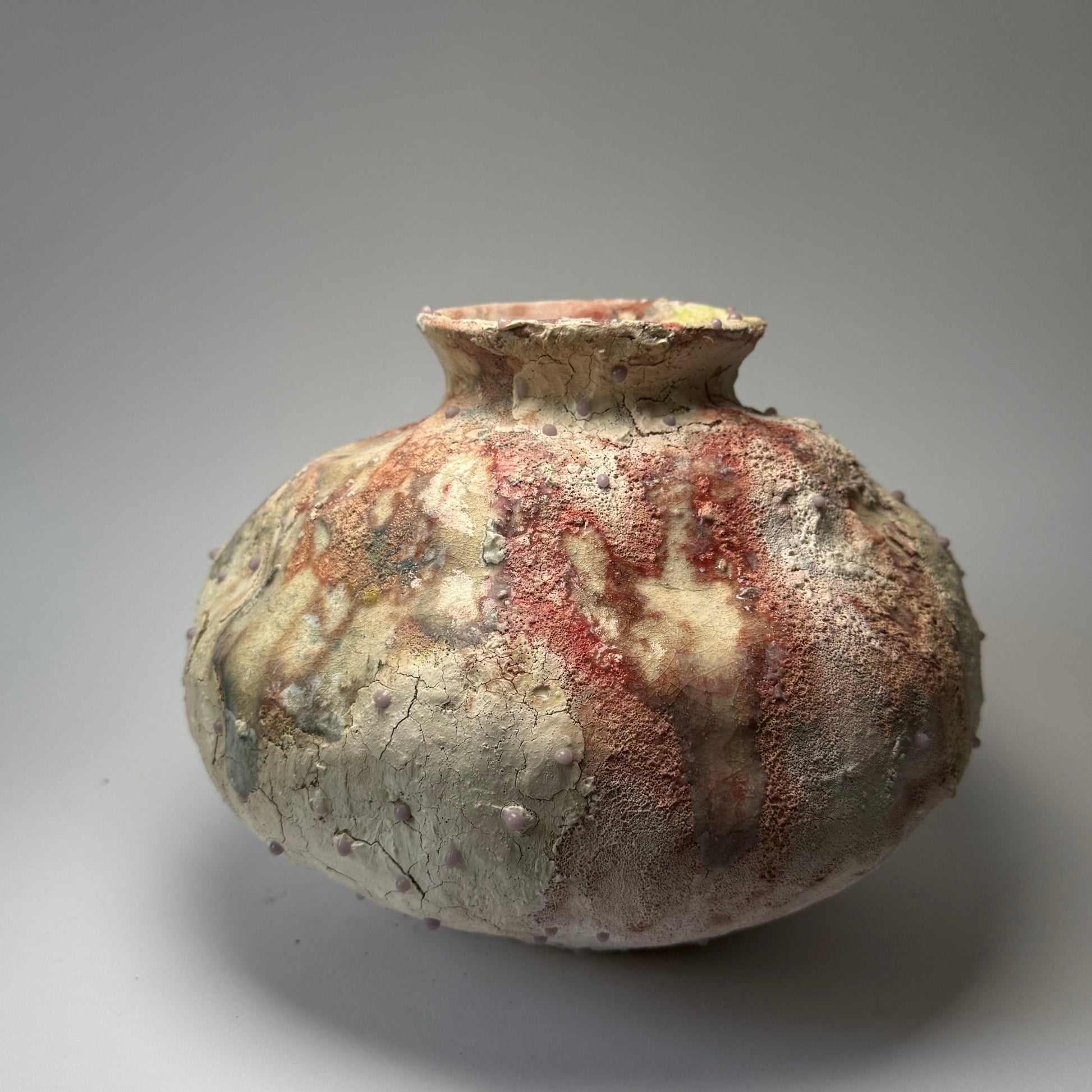 Decorative ceramic vase with textured surface on a gray background