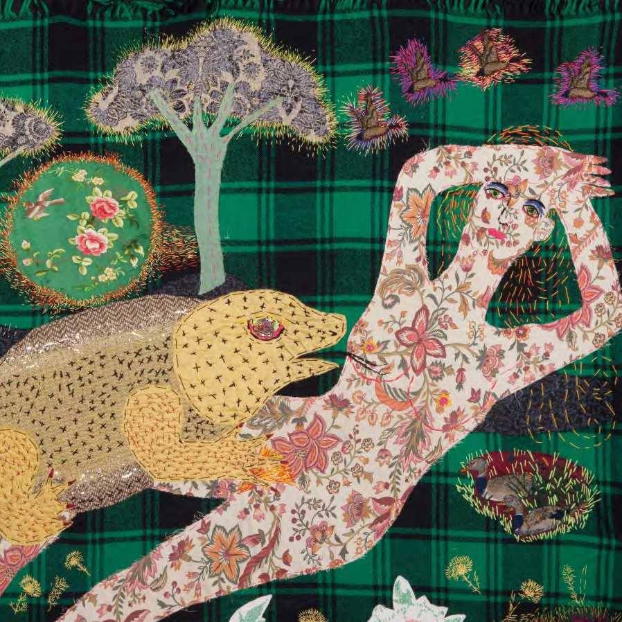 Decorative blanket with embroidered leopards and floral patterns on a green plaid background.