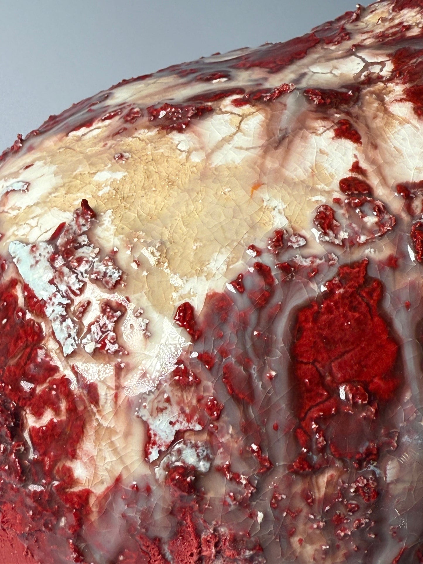 Close-up of a red and beige vase with a gray background