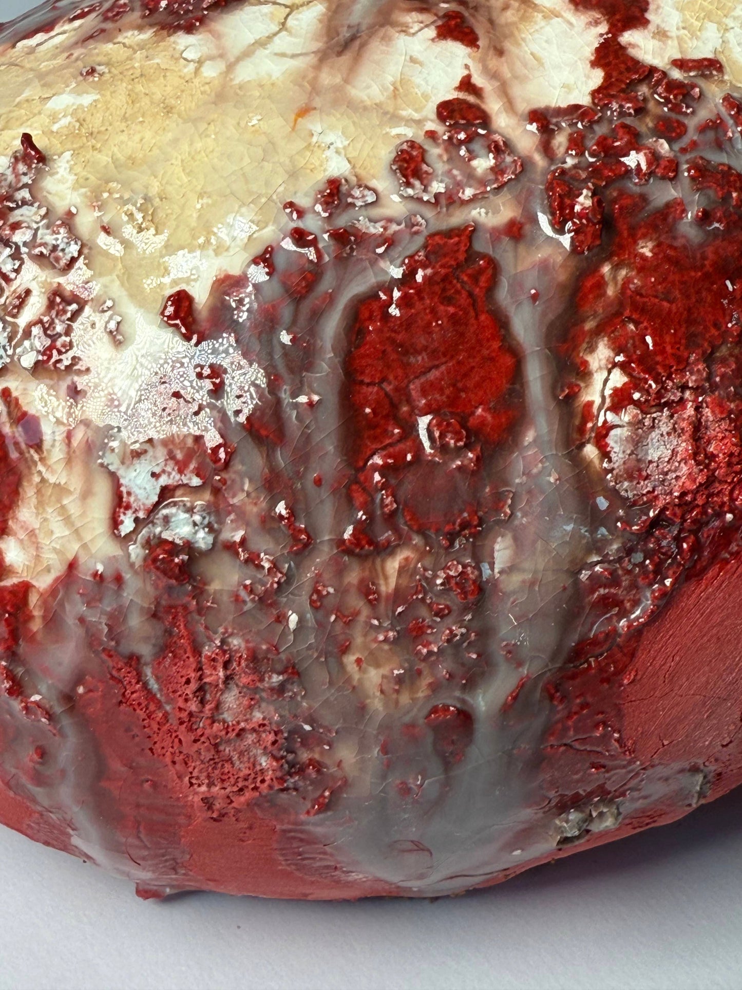 Close-up of a red and white interior vase with a creamy texture