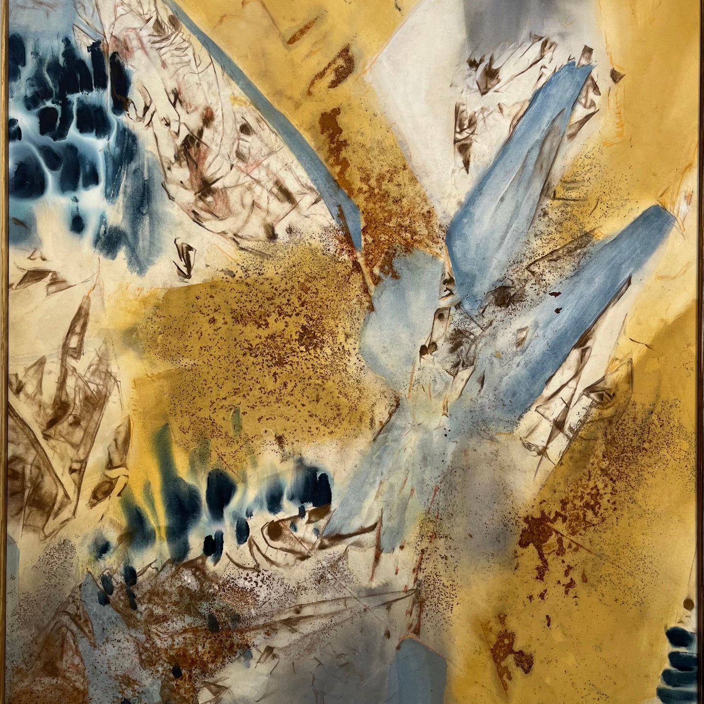 Abstract artwork featuring a blend of gold, blue, and beige tones with dynamic textures and a signature in the upper right corner.