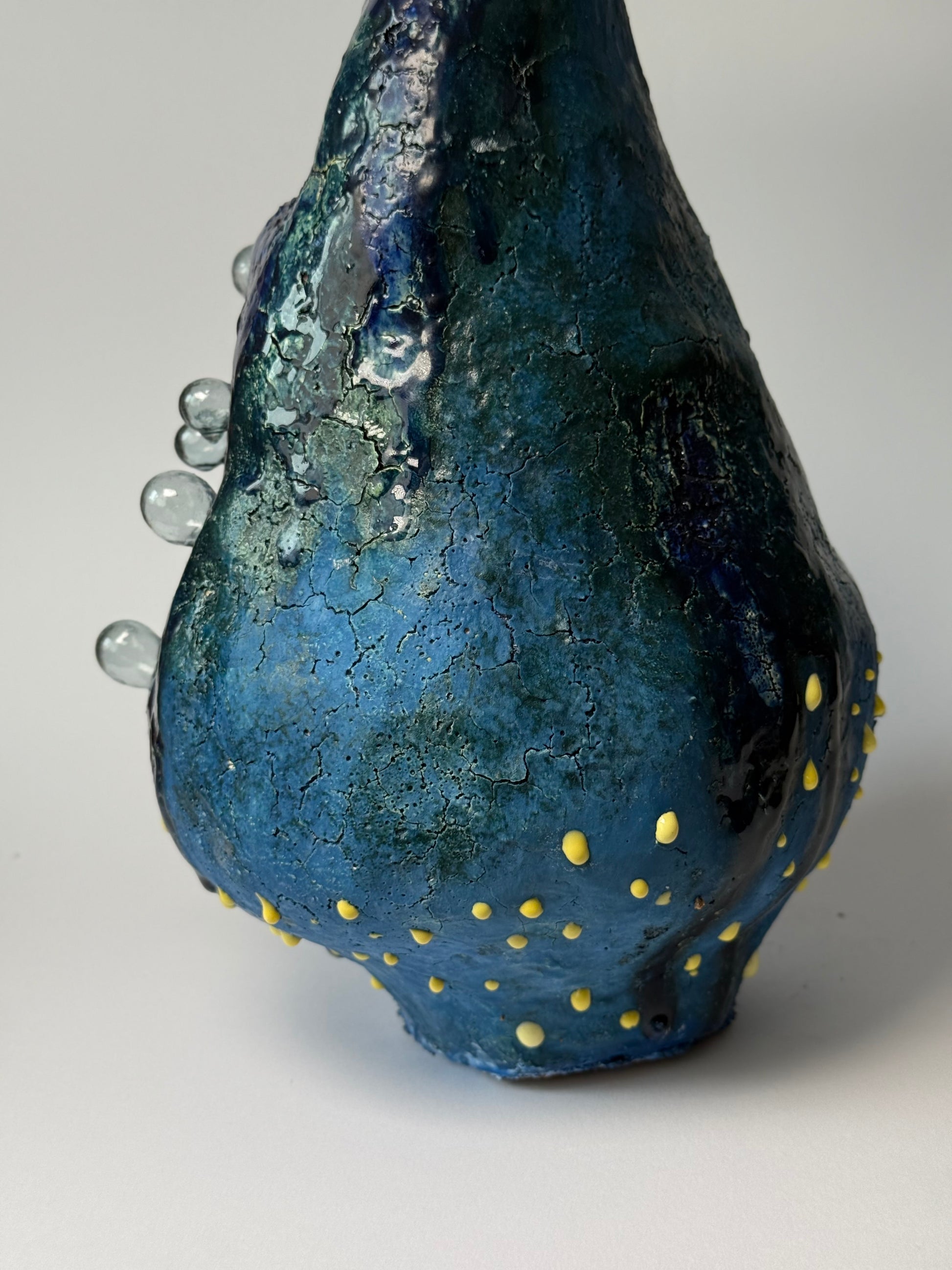 Blue ceramic interior vase with gold dots on a gray background for modern home