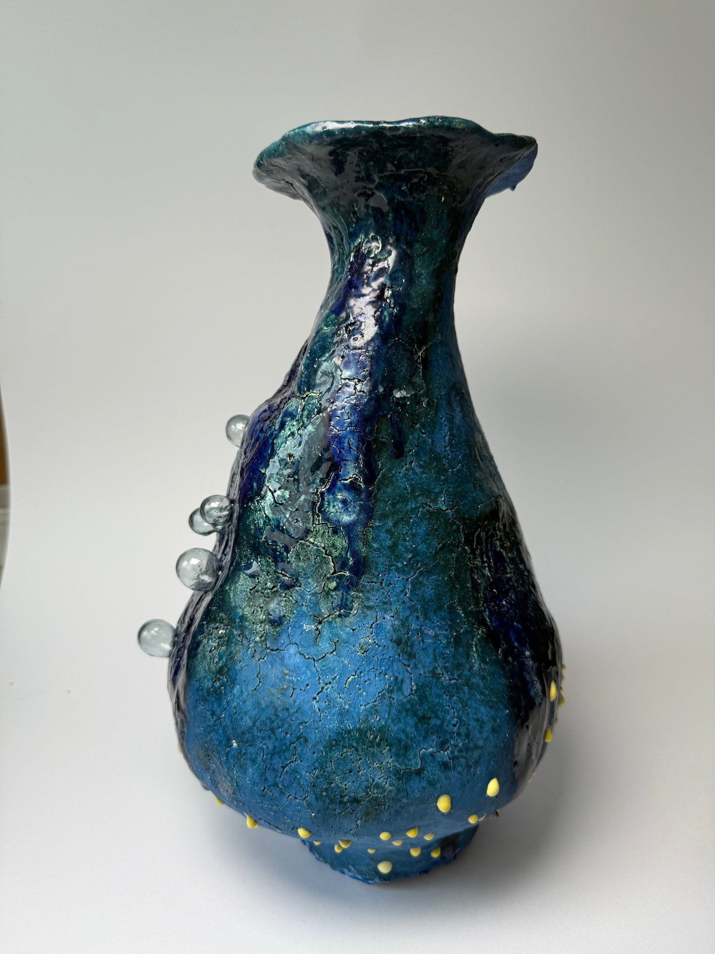 Blue vase for modern interior with a blue and yellow textured surface on a white background