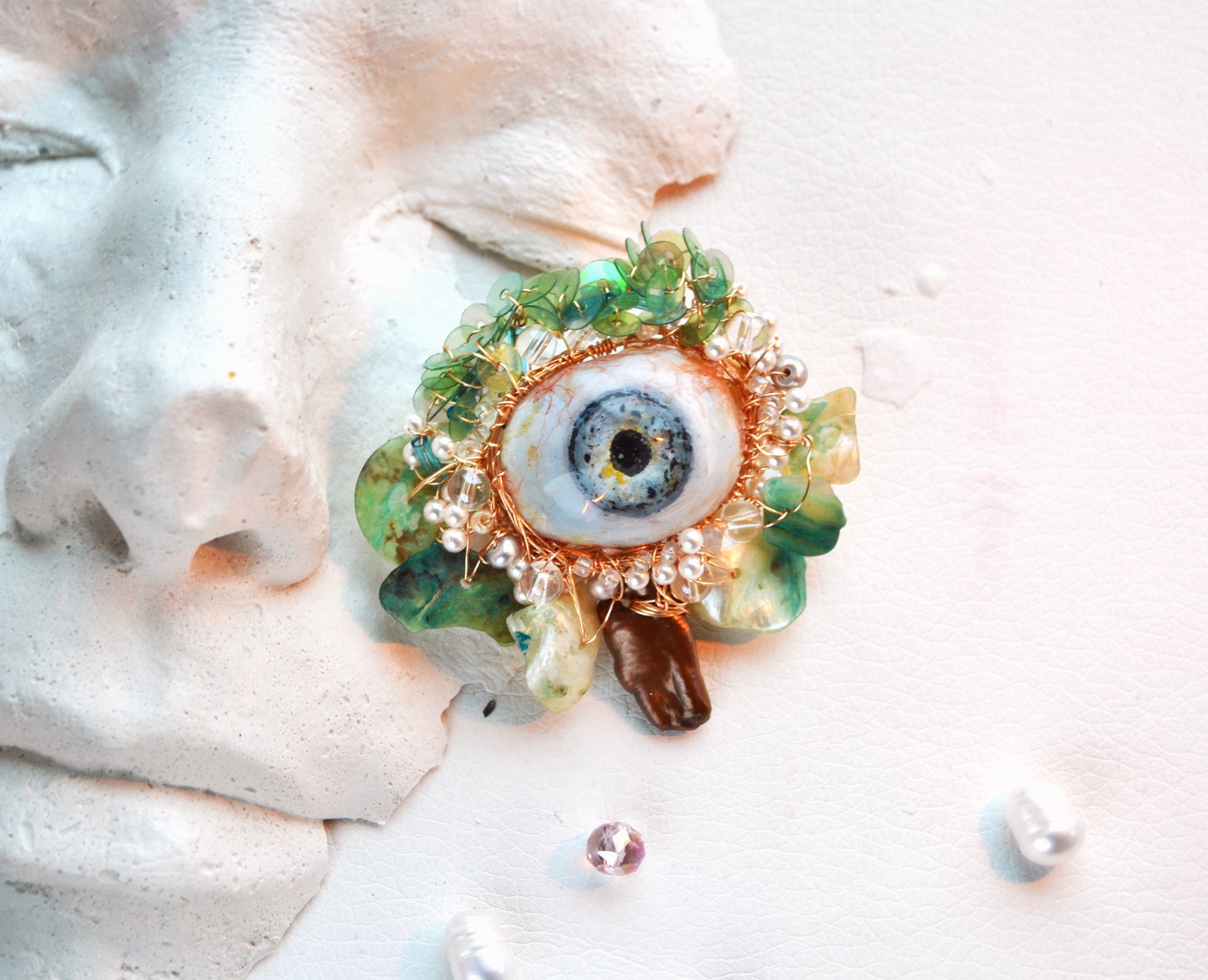 Decorative brooch with eye design on a white surface