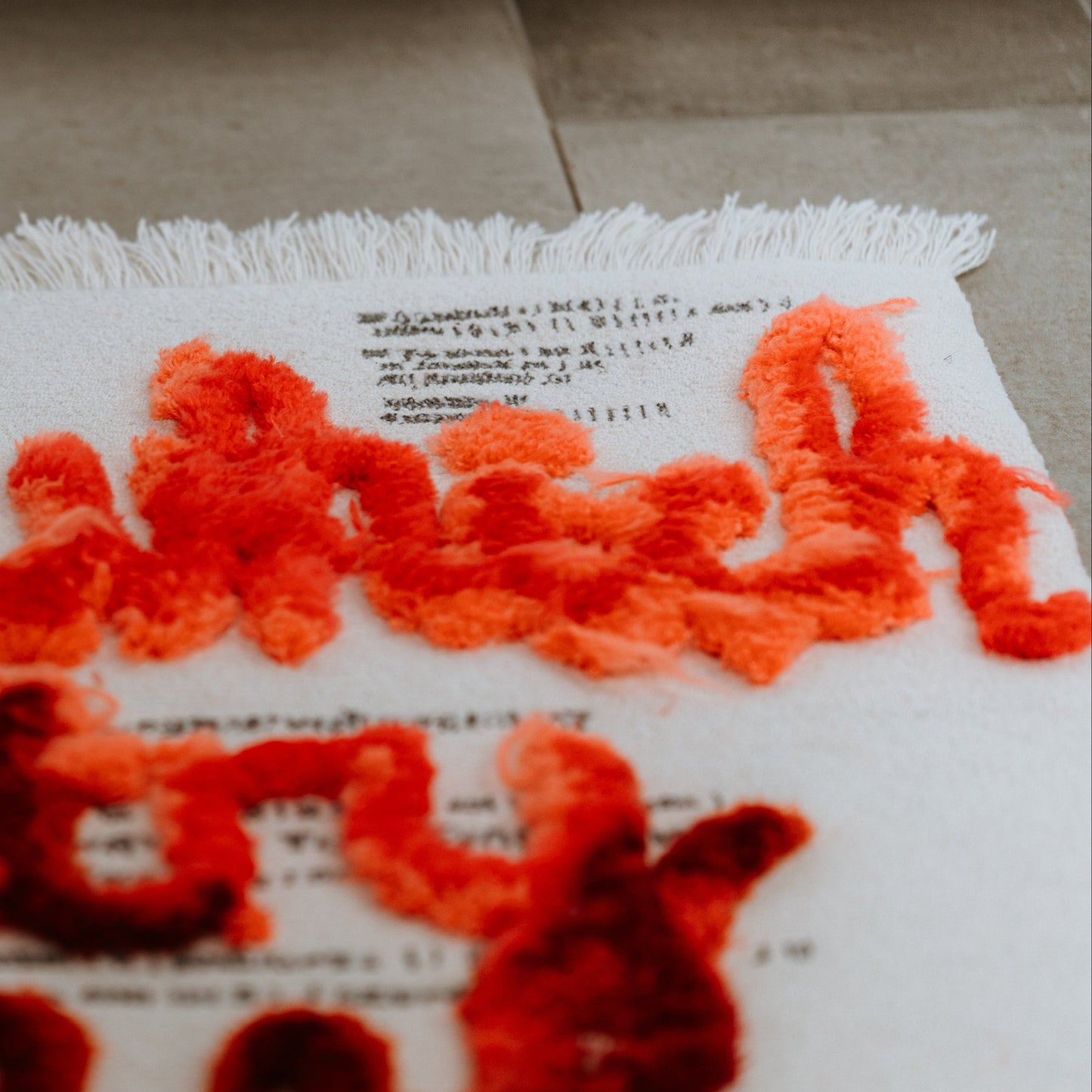 Textured orange and black rug with calligraphy letters 