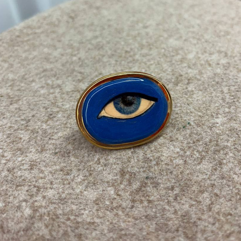 Ring with eye design on a textured surface