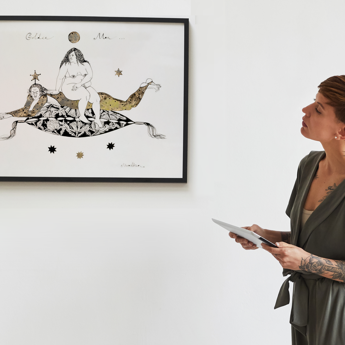 A woman looking at a framed artwork of Nina Murashkina