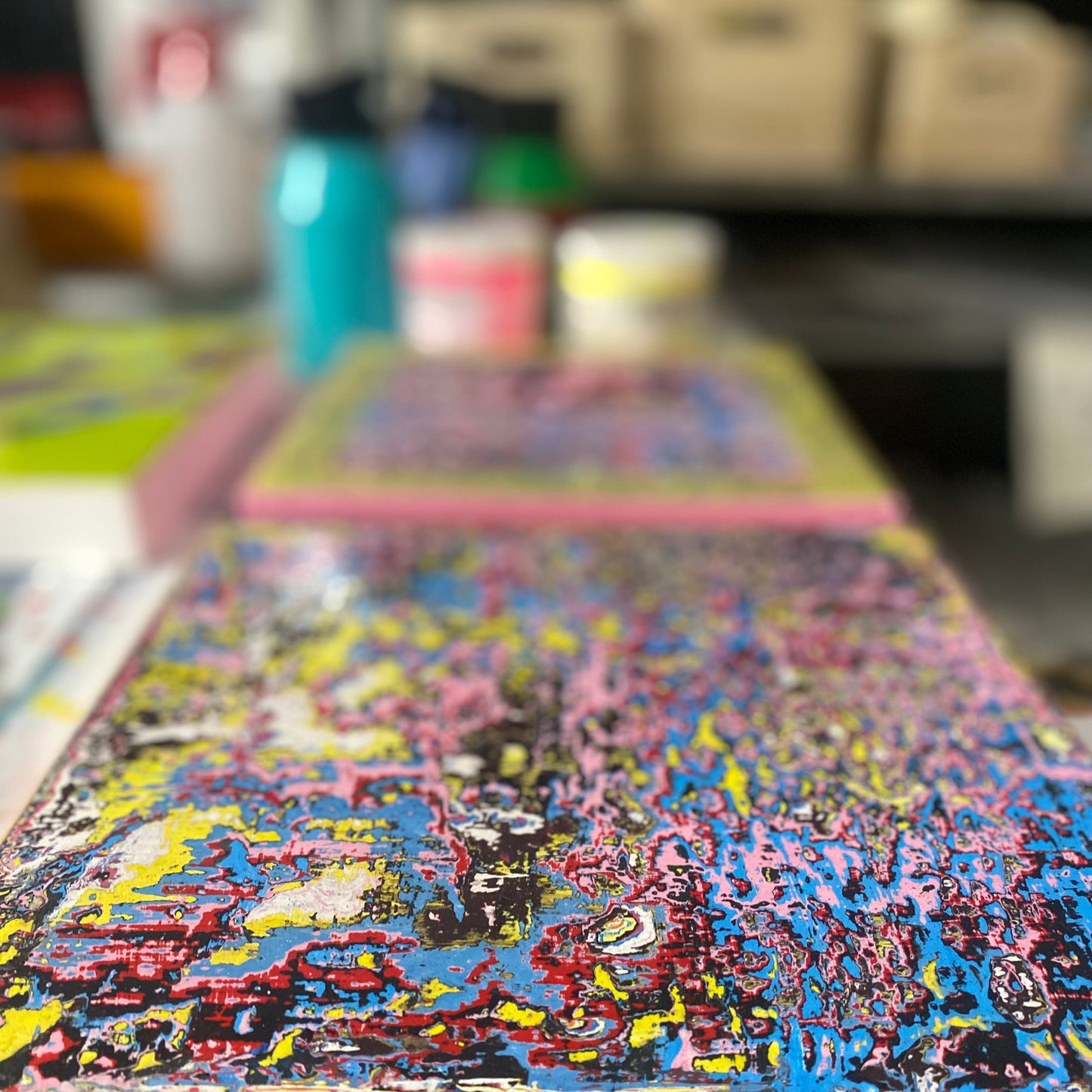 Colorful abstract painting on a table with a blurred background, artist Neil Lorenzo studio