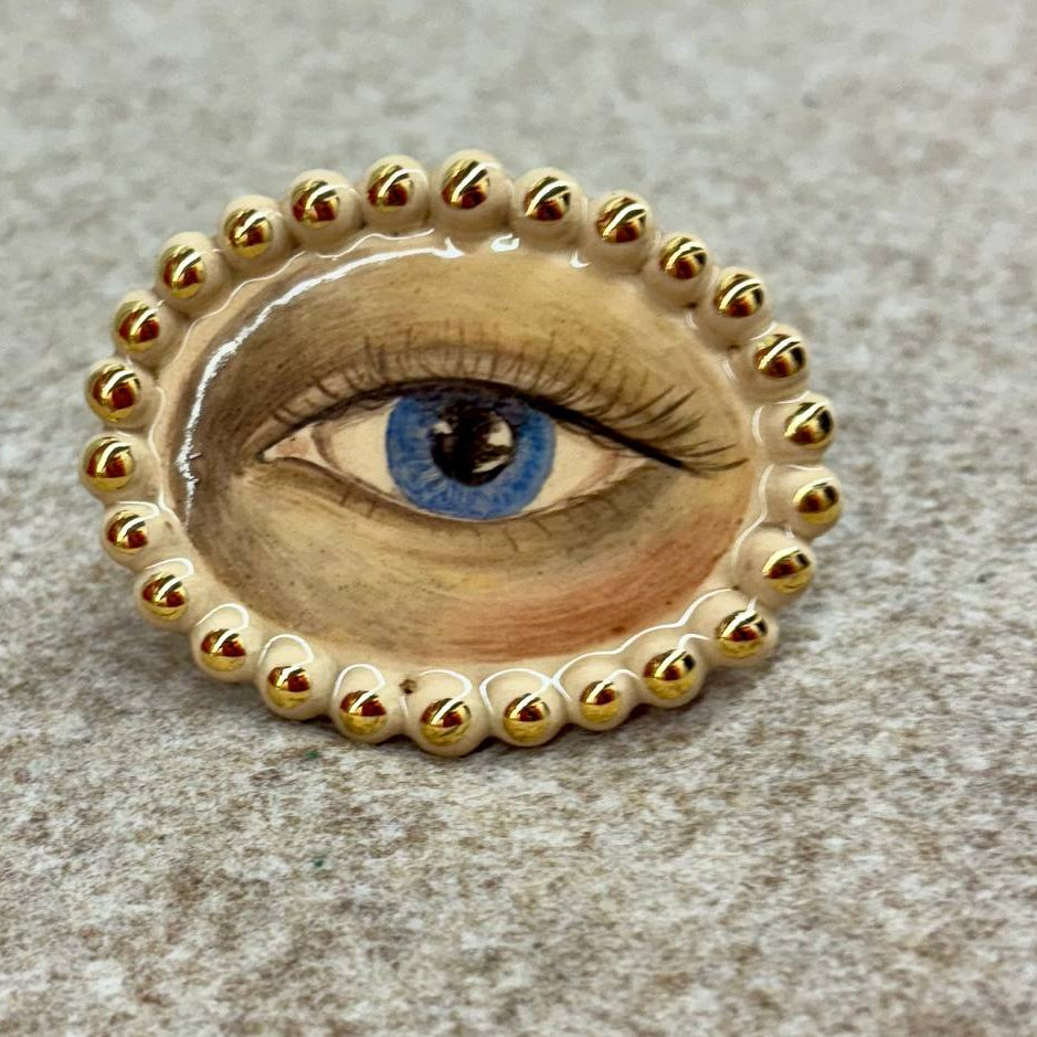 Ring with eye design on a textured surface