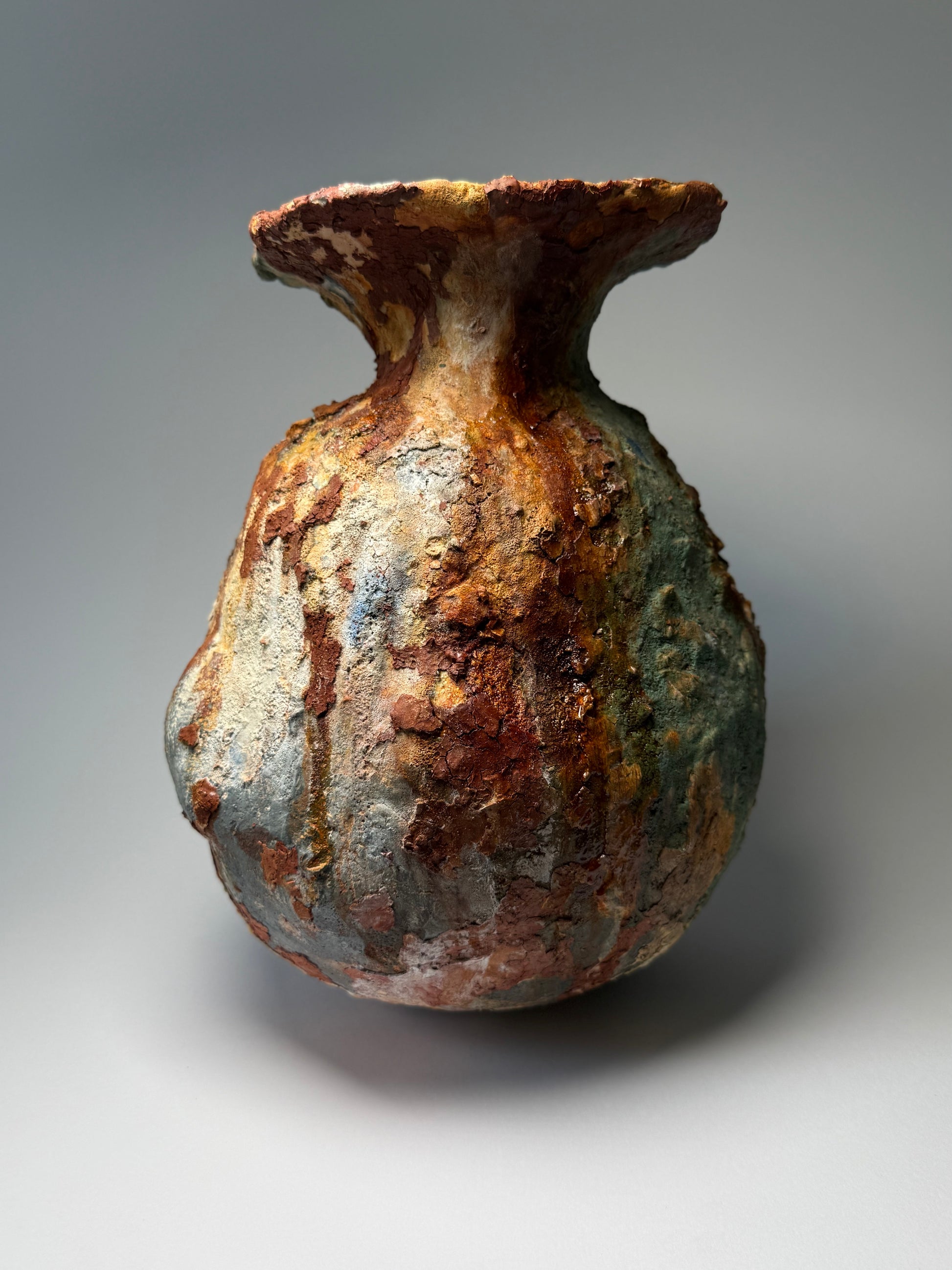 Rust-colored ceramic vase on a gray background