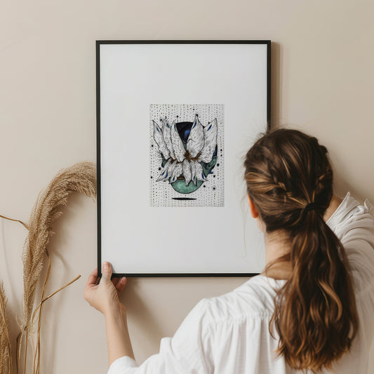 A person hanging a framed graphics artwork on a wall